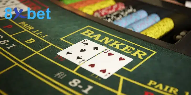 Hai lá bài 5 bích và 4 cơ đặt trên ô Banker của bàn Baccarat