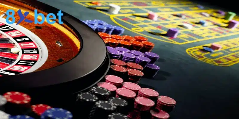 Bánh xe roulette và các chồng chip cược nhiều màu trên bàn casino online
