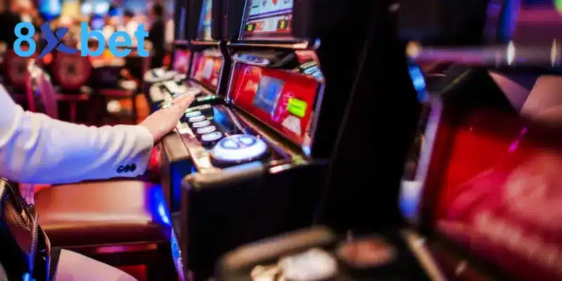 Người chơi nhấn nút trên máy slot đèn đỏ trong sảnh casino