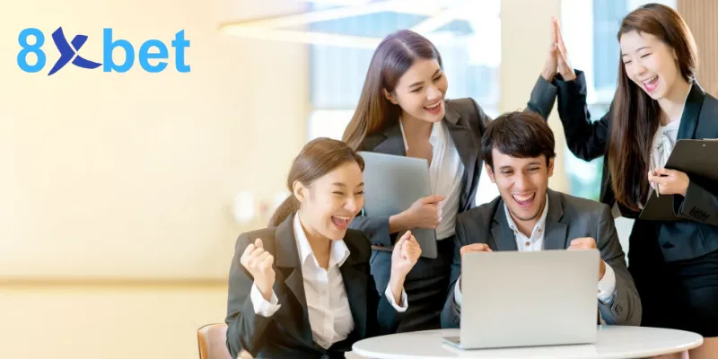 Nhóm đối tác mặc vest vui mừng khi cùng xem kết quả trên máy tính xách tay