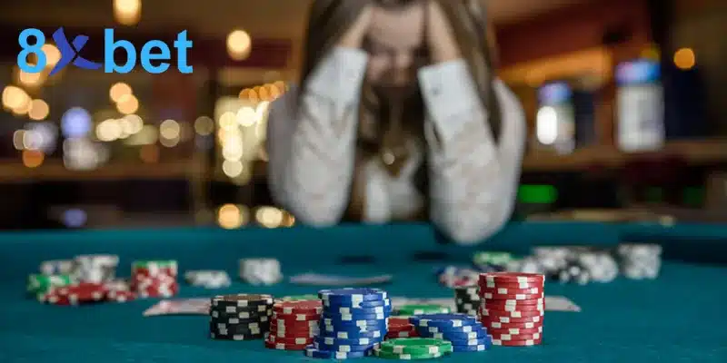 Người chơi ôm đầu căng thẳng bên bàn đầy chip cược