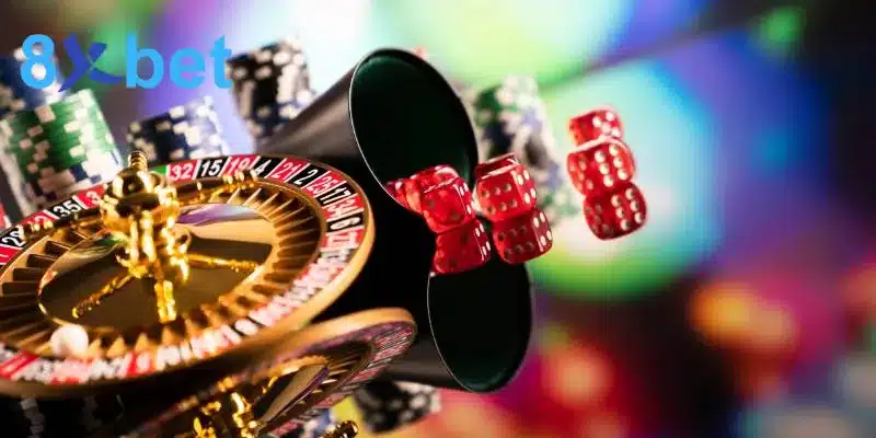 Bánh xe roulette mạ vàng cùng ống lắc và xúc xắc đỏ trong sảnh live casino 8XBET