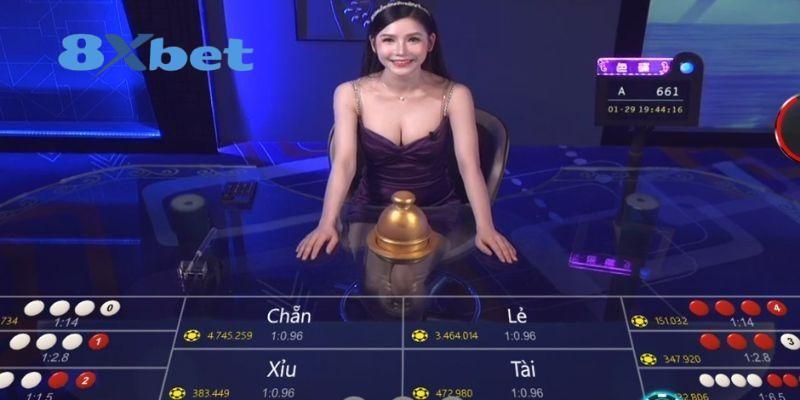 Nữ dealer ngồi sau bàn sicbo trực tiếp với các ô cược Chẵn, Lẻ, Tài, Xỉu
