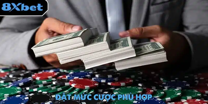 Người chơi cầm nhiều xấp tiền phía trên mặt bàn phủ đầy phỉnh poker