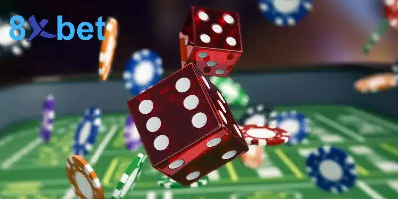 Hai viên xúc xắc đỏ rơi trên bàn cược xanh giữa nhiều chip casino